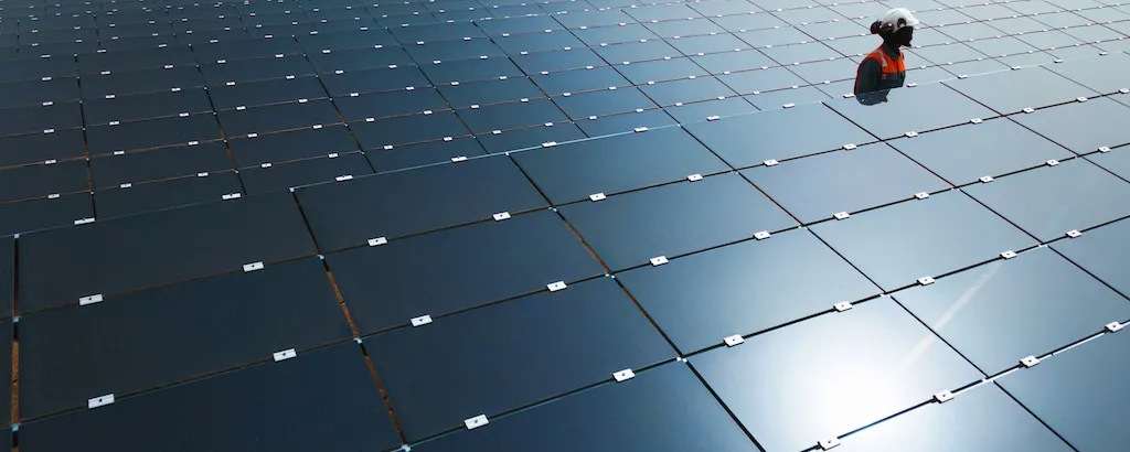 O&M Engineer walking between solar panels