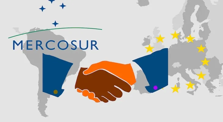 Trade agreement between Mercosur and the EU -   On the maps of South America and Europe are the respective symbols. In front of it the illustration of a handshake as a symbol for a contract.